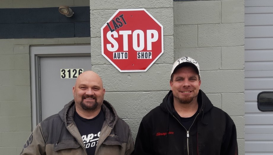 Ron Keifer Jr. and James Leake II beneath the Last Stop Auto Shop sign